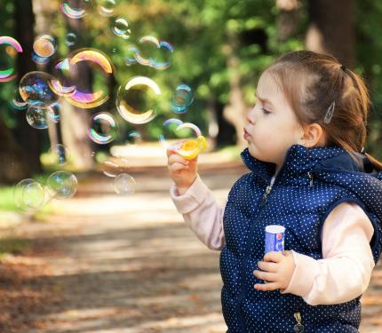 Una bambina fa le bolle di sapone