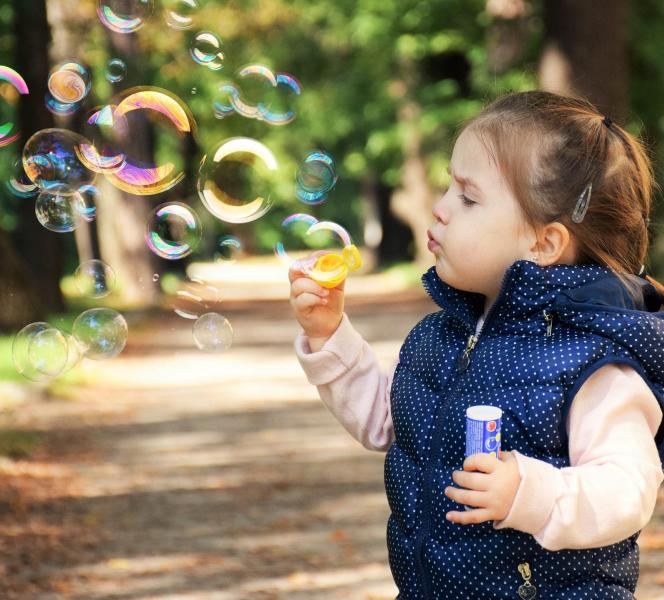 Una bambina fa le bolle di sapone